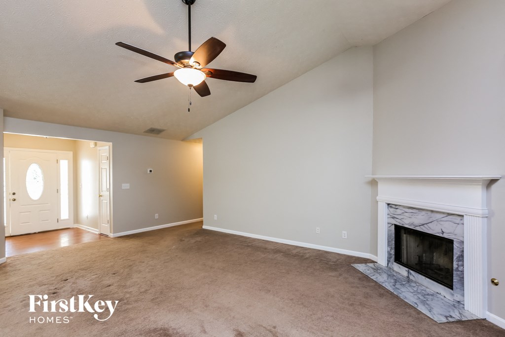 a living room with a fireplace and a ceiling fan