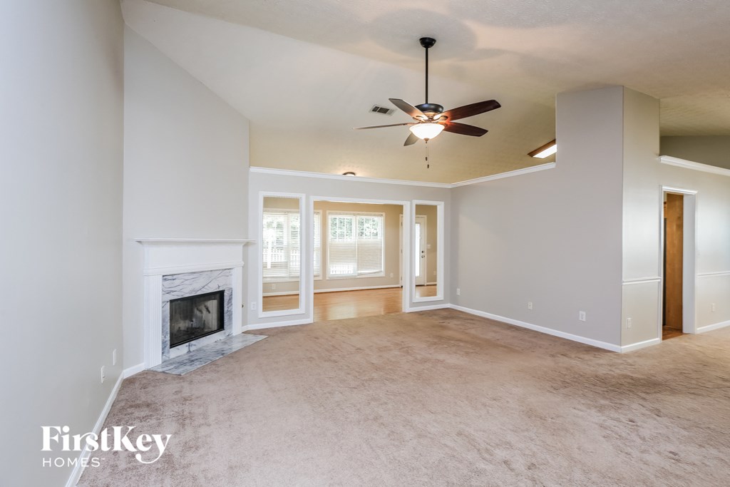 a living room with a fireplace and a ceiling fan