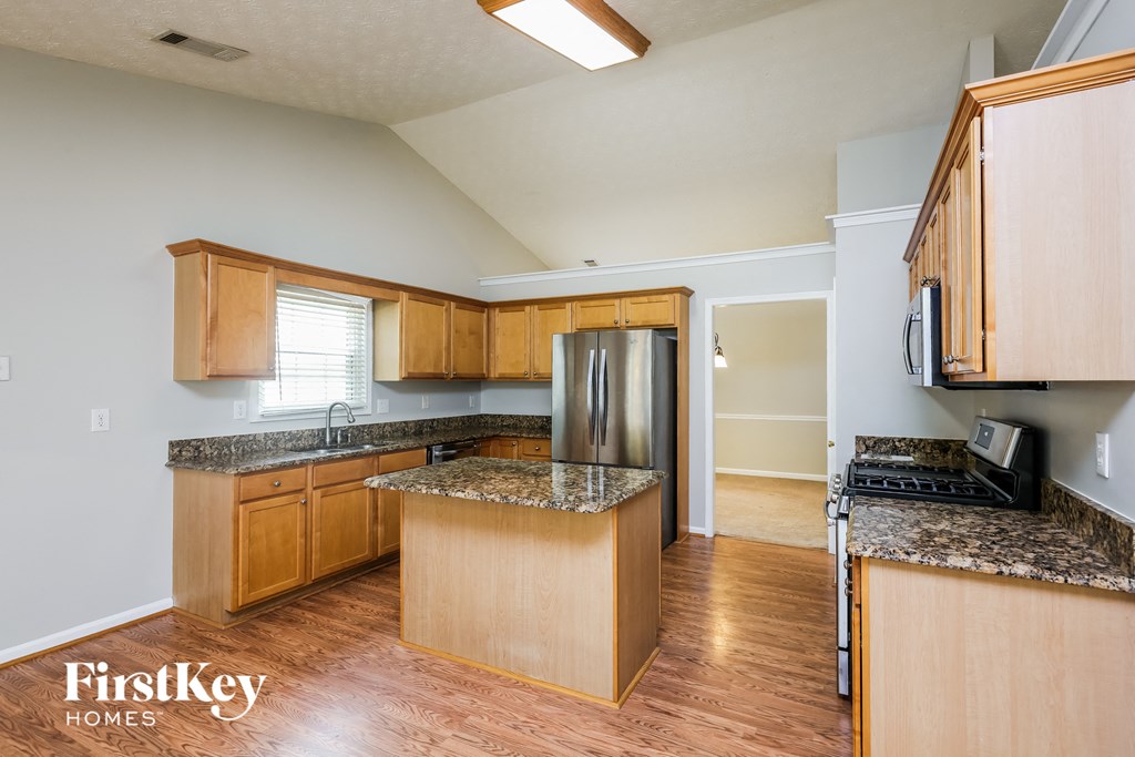 an empty kitchen with wooden cabinets and granite counter tops