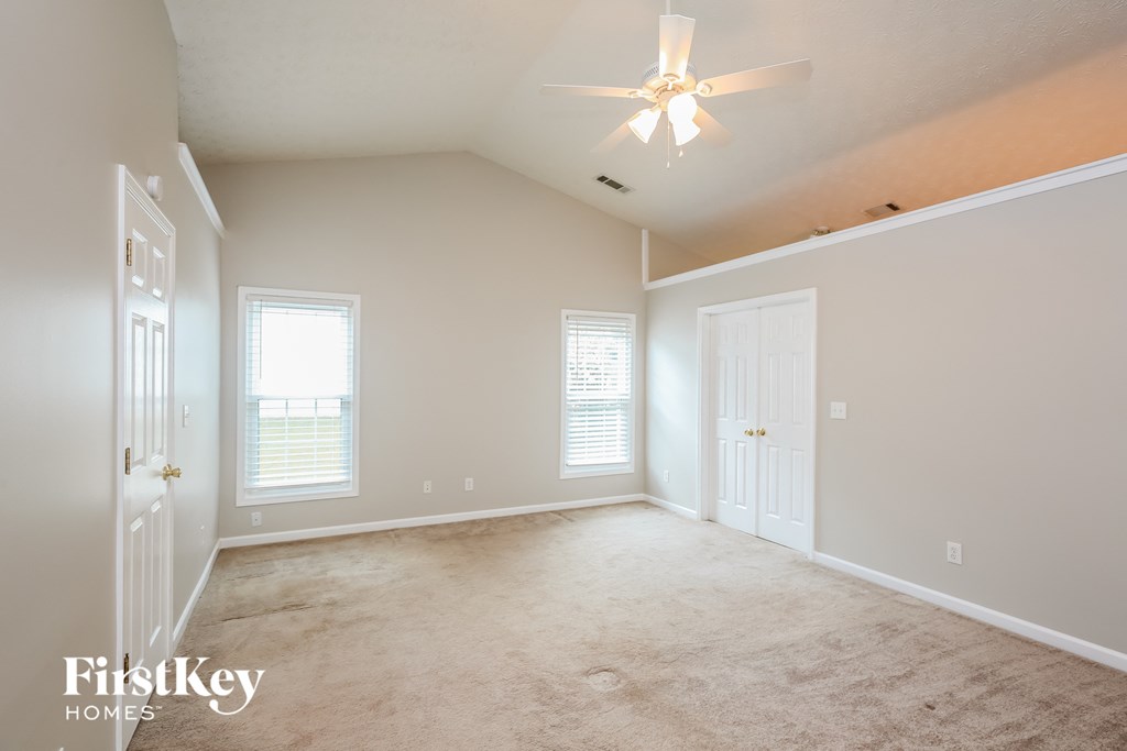 a bedroom with a carpeted floor and a ceiling fan