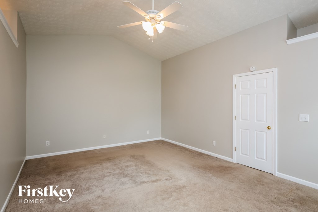 a bedroom with a carpeted floor and a ceiling fan