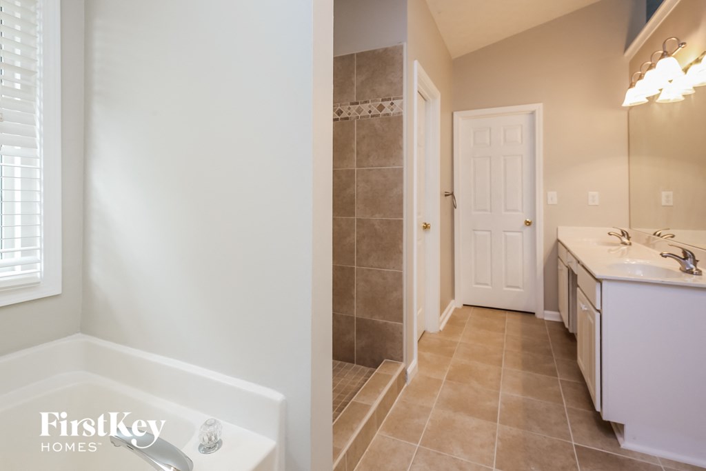 a bathroom with a tub and a sink and a shower