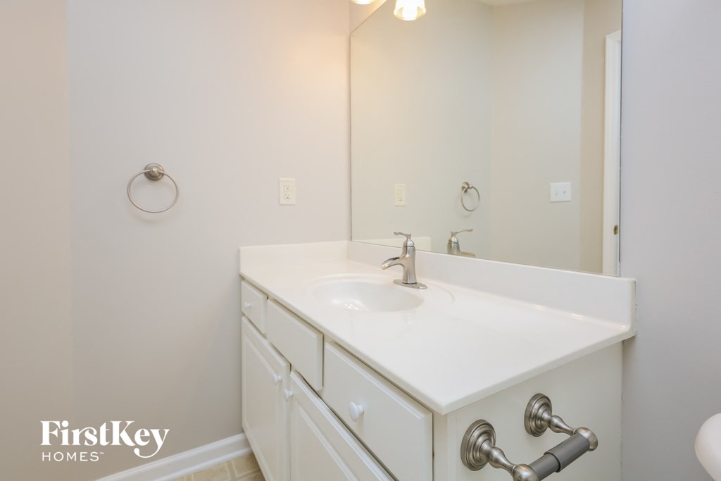 a white bathroom with a sink and a mirror
