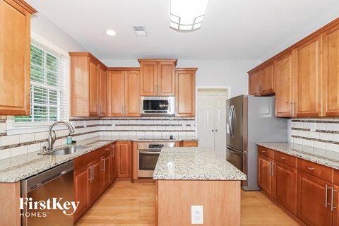 A kitchen with wooden cabinets and a granite countertop.