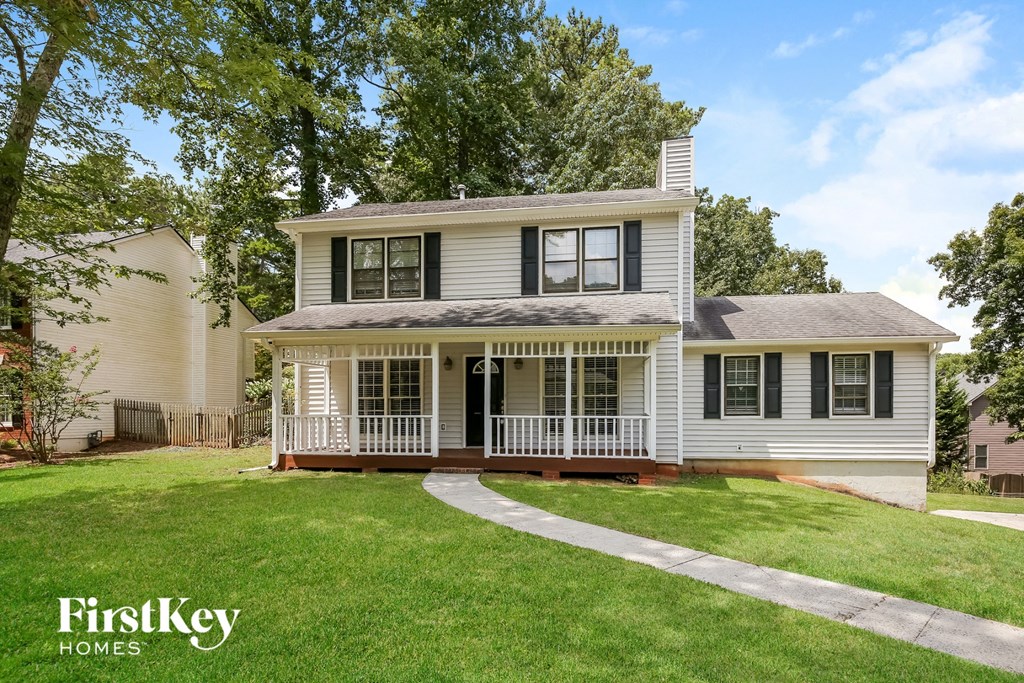a white house with a front porch and a lawn