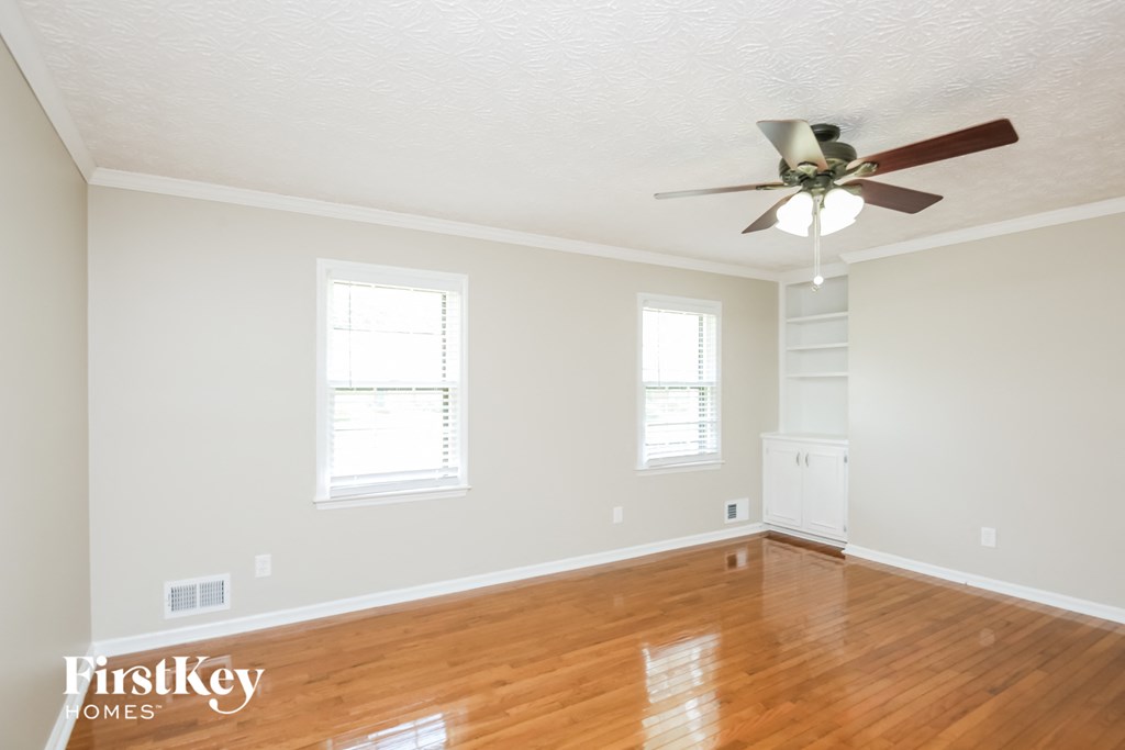 a living room with wood floors and a ceiling fan