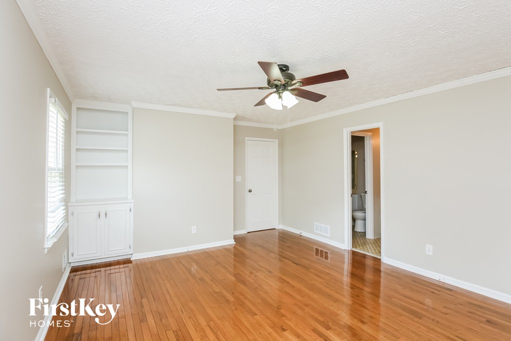 a living room with wood floors and a ceiling fan