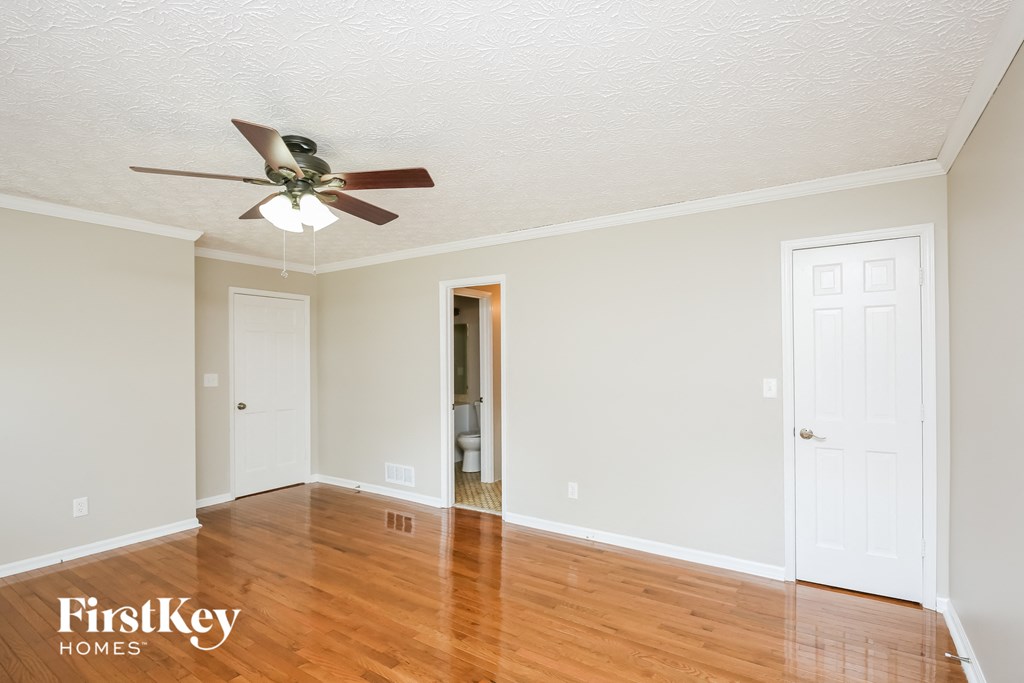 a living room with wood floors and a ceiling fan