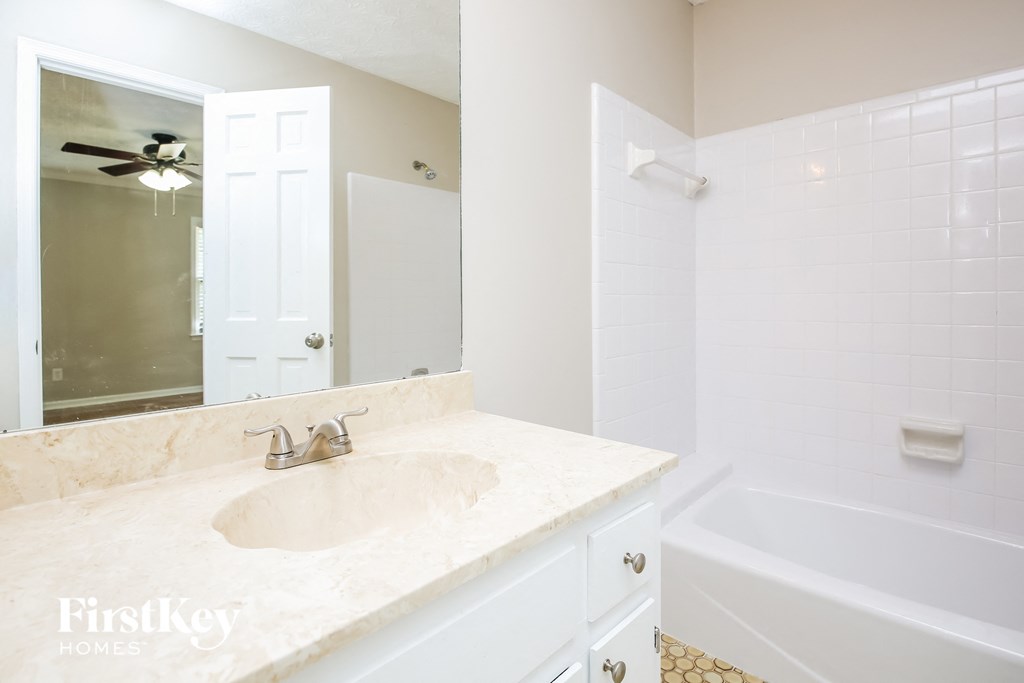 a bathroom with a sink and a tub and a mirror
