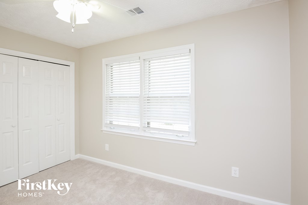a bedroom with a large window and a white door