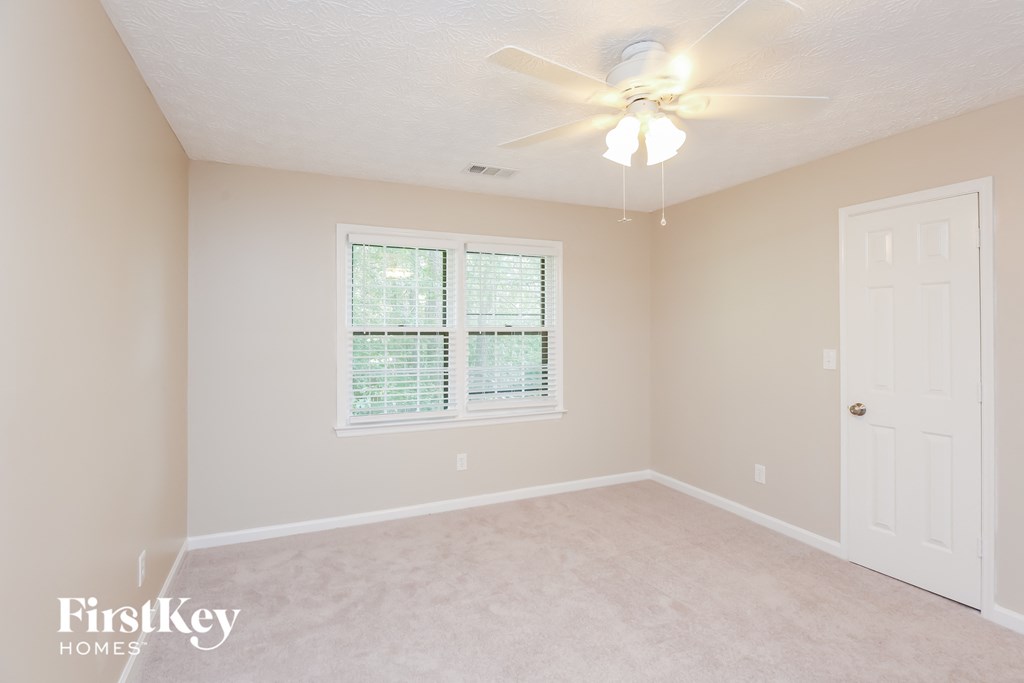 a bedroom with a ceiling fan and a window