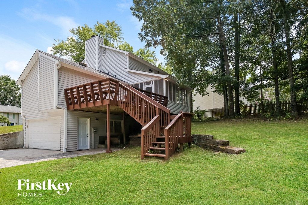 a white house with a wooden deck on the side of it