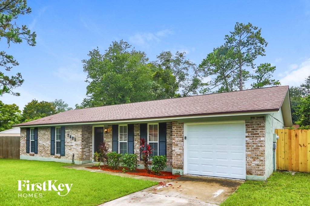 A house with a garage door and a sign that says "FirstKey Homes".