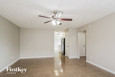 A spacious room with a ceiling fan and tiled floor.