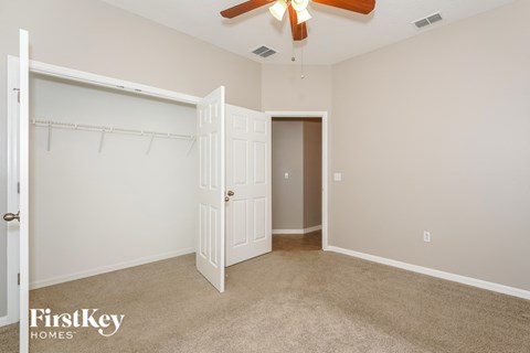 A bedroom with a white door and a white closet.