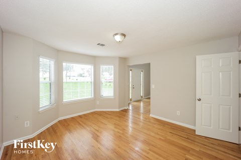 the living room and dining room with wood floors and white walls