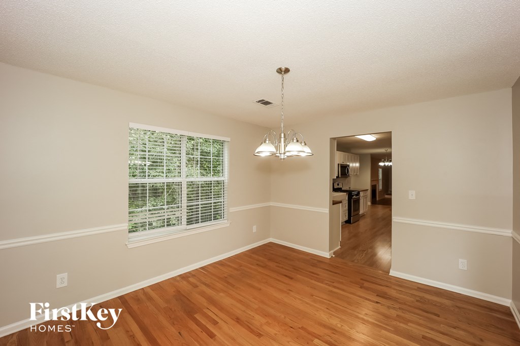 an empty living room with wood floors and a large window