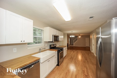 a kitchen with white cabinets and stainless steel appliances and a wooden floor