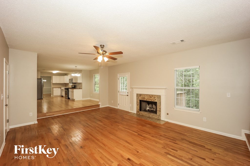 the living room and dining room with wood flooring and a fireplace
