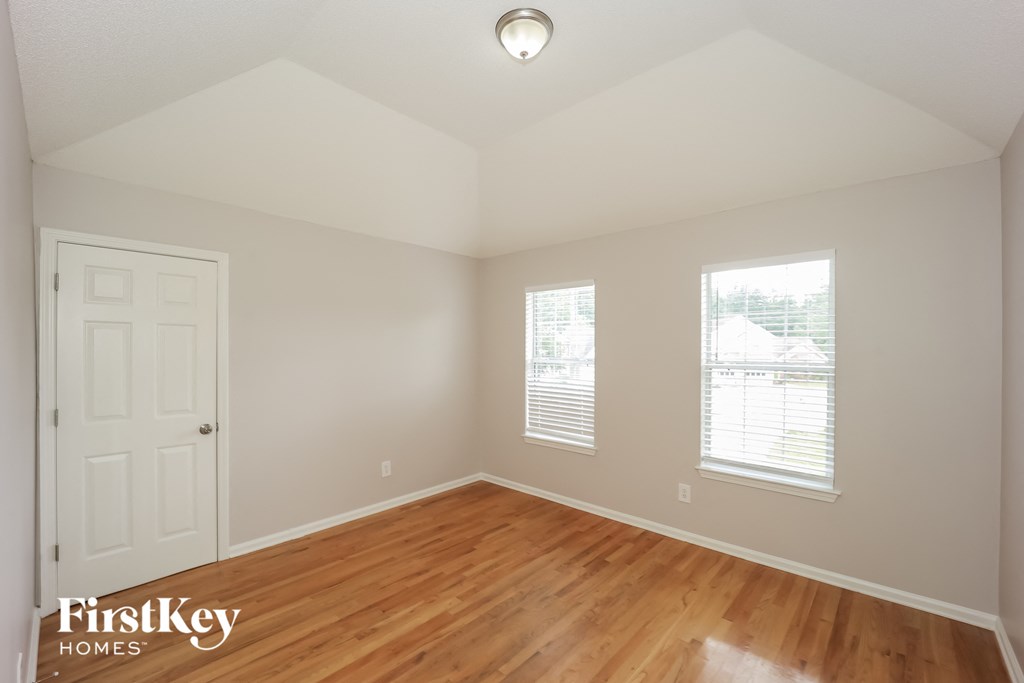 a bedroom with a hard wood floor and a white door