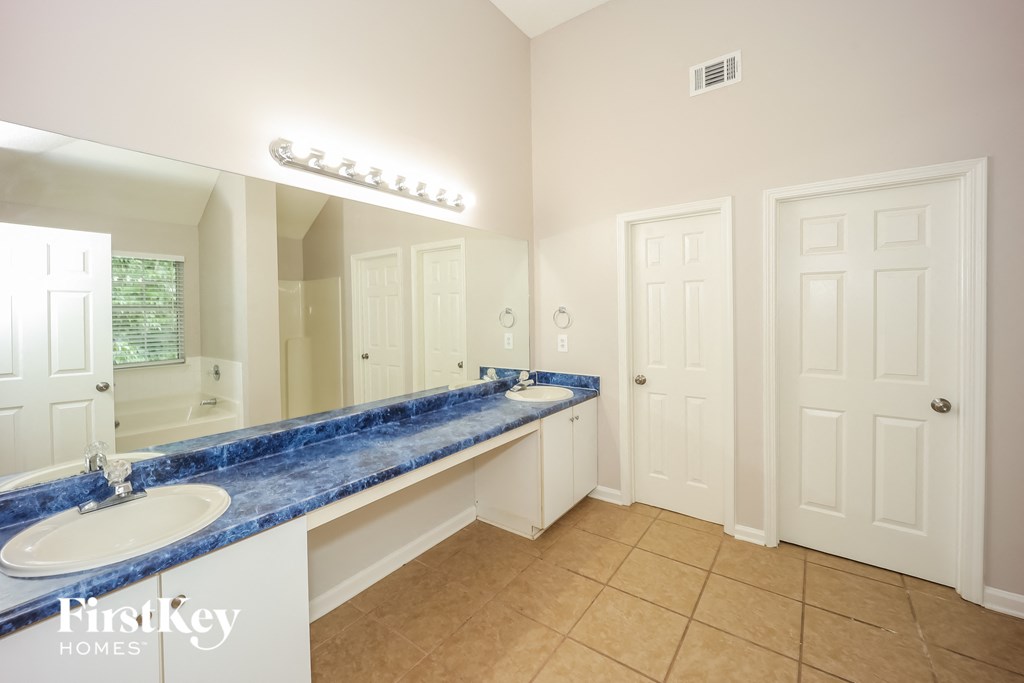a bathroom with two sinks and a large mirror