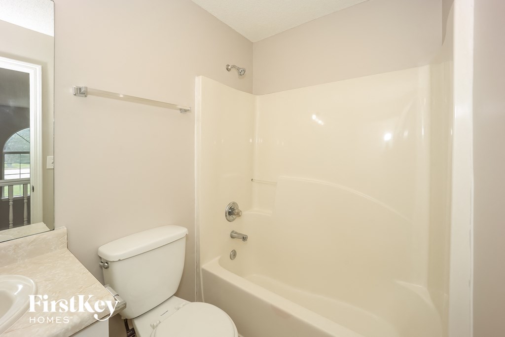 a bathroom with a tub and a toilet and a sink