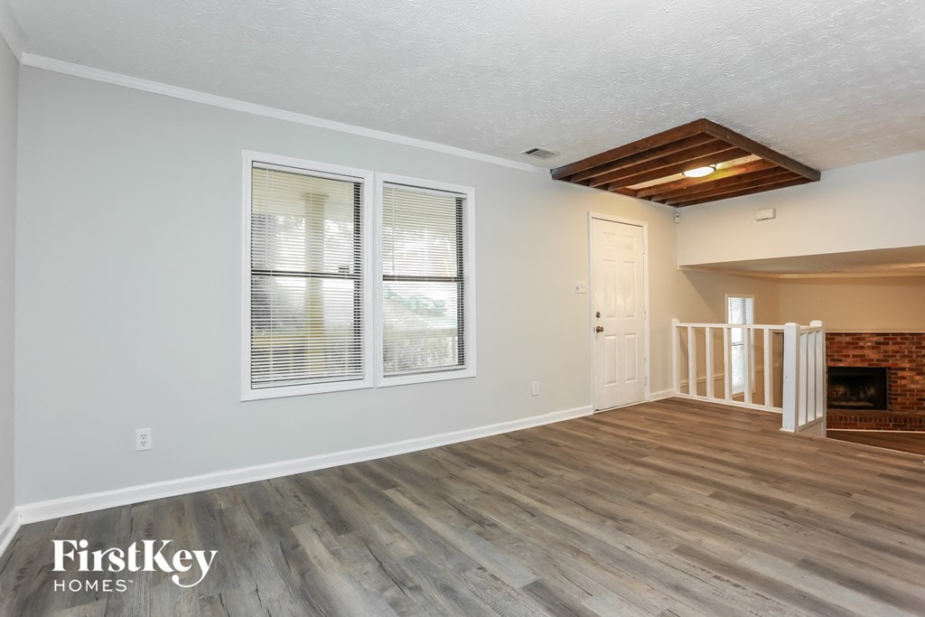 the living room of a home with a wood floor and a fireplace