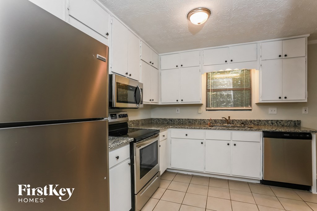 a kitchen with white cabinets and stainless steel appliances