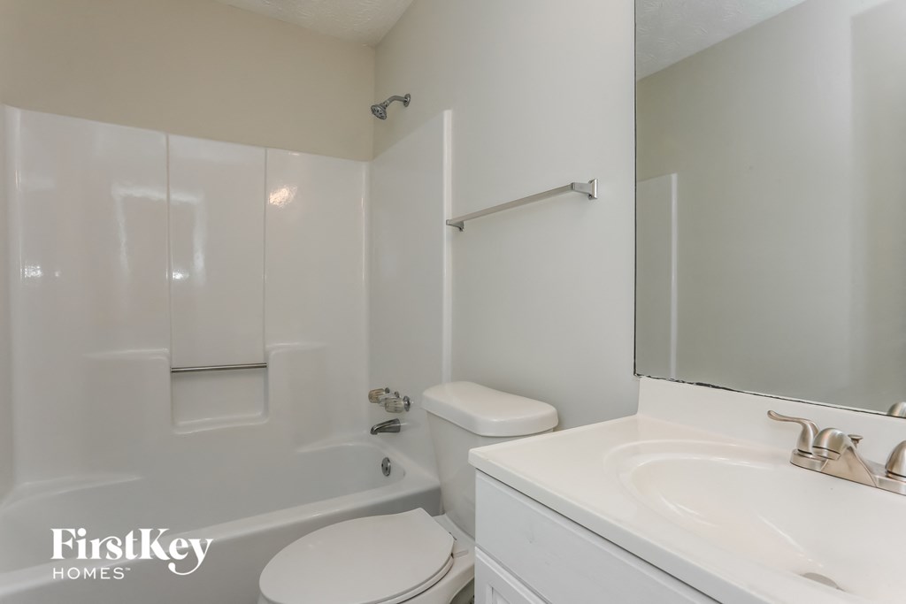 a white bathroom with a sink toilet and bath tub