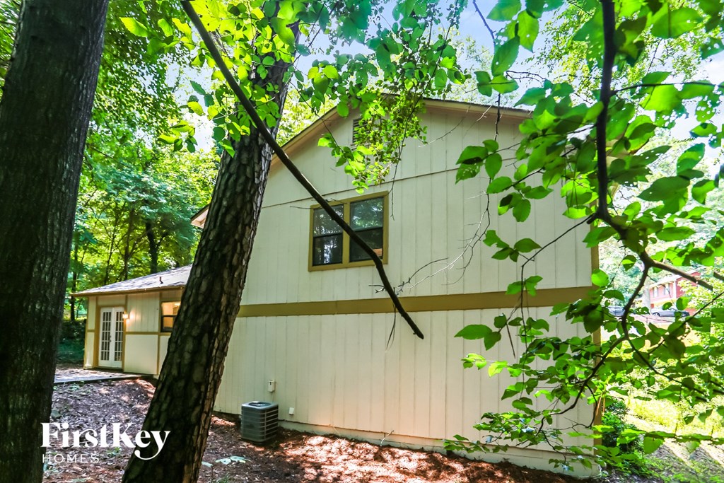 a white house in the woods with trees