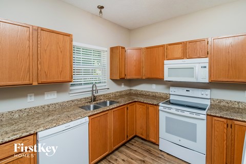 A kitchen with wooden cabinets and white appliances.