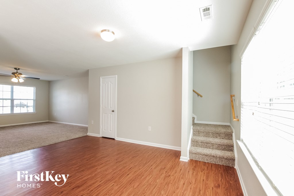 an empty living room with wood floors and a white door