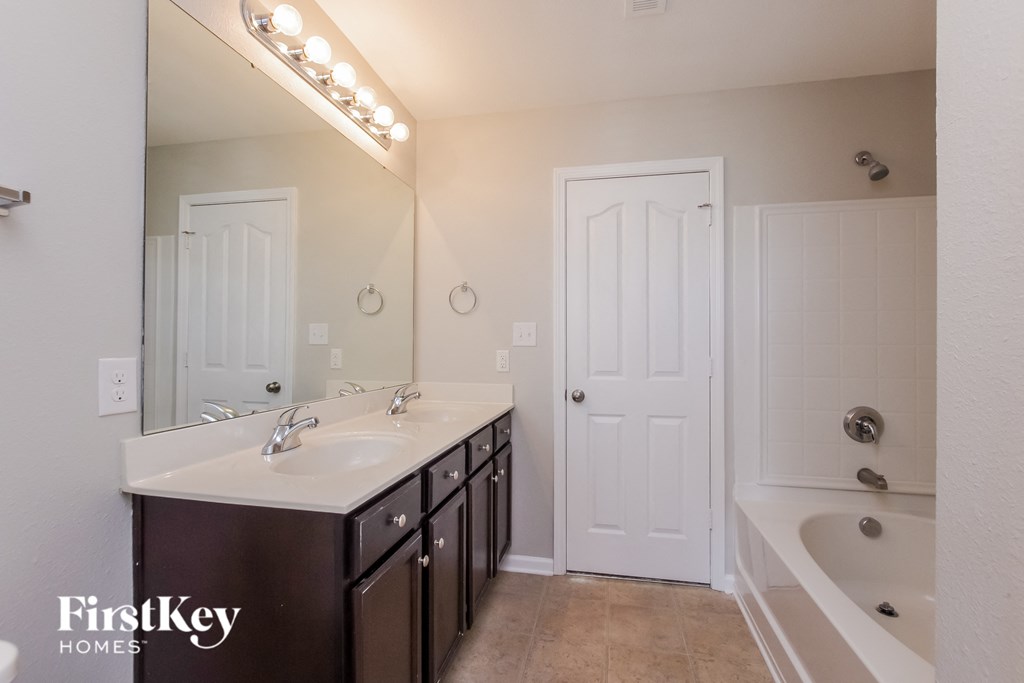 a bathroom with a sink and a tub and a mirror
