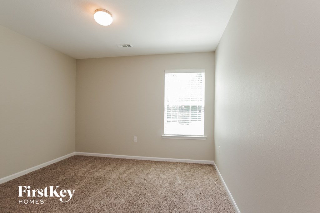 an empty room with carpet and a window