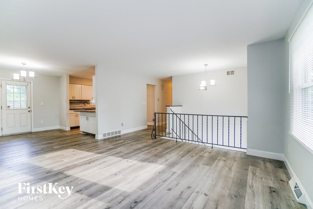 A spacious living room with wooden floors and a balcony.