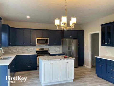 a kitchen with black cabinets and a white island