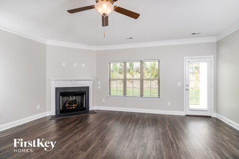 a living room with a fireplace and a ceiling fan