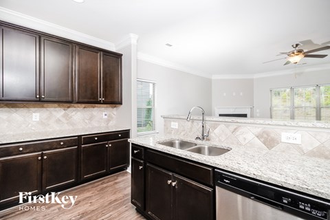a kitchen with wooden cabinets and granite counter tops and a sink