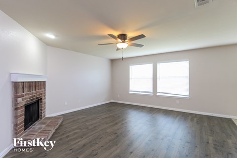 a living room with a fireplace and a ceiling fan