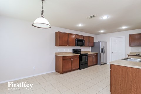 a kitchen with wooden cabinets and a white tile floor