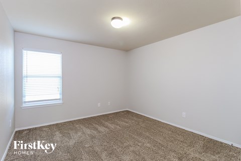 the upstairs bedroom has a carpeted floor and a window
