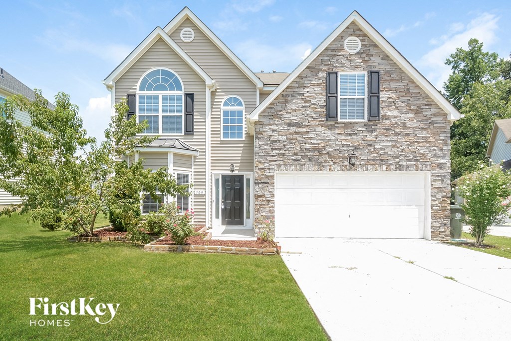 A house with a stone facade and a white garage door.