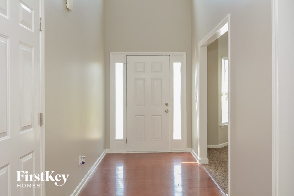 A white door is in the middle of a hallway.