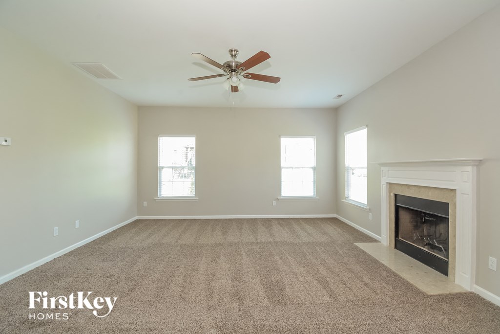 A spacious room with a fireplace and a ceiling fan.
