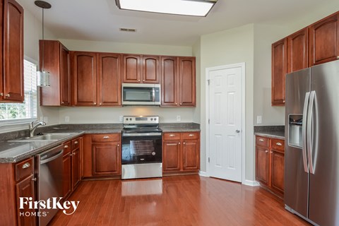 A kitchen with wooden cabinets and a stainless steel refrigerator.