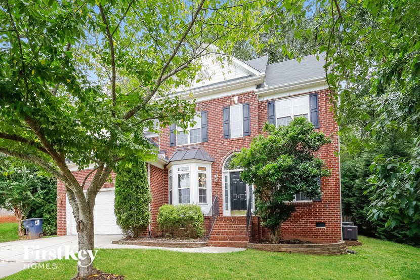 A brick house with a tree in front.