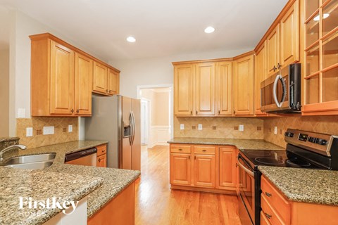 A kitchen with wooden cabinets and granite countertops.
