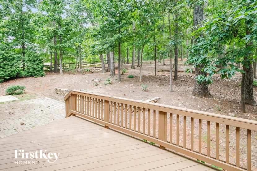 A wooden deck overlooks a forest of trees.
