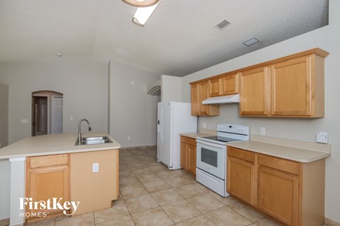 a kitchen with white appliances and wooden cabinets