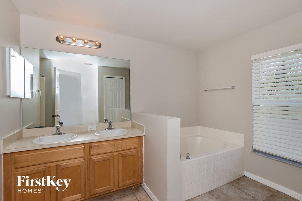a bathroom with two sinks and a bath tub